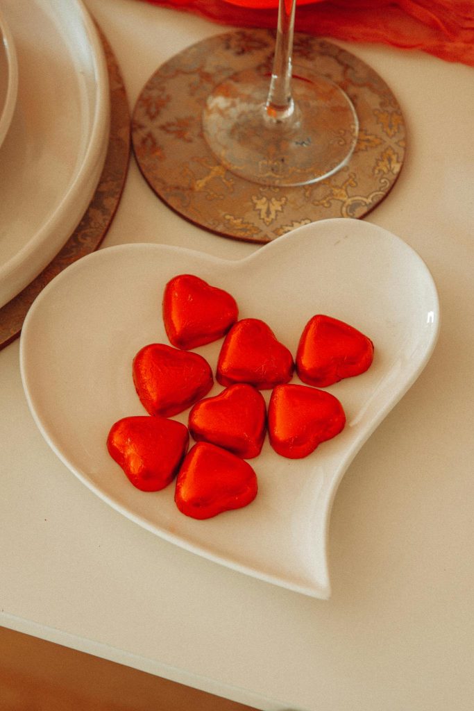 Heart-shaped plate filled with red heart chocolates, symbolizing Valentine’s Day gifts and romantic surprises in Singapore. - same day flower delivery Singapore | ValentineDay.sg